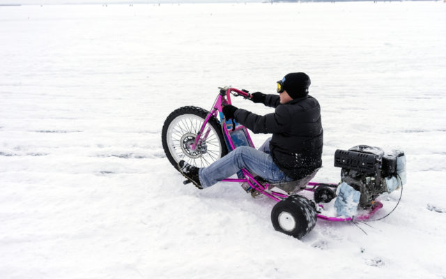 Guy riding a drift trike on snow