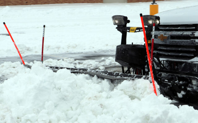 A truck using a snowplow with snowplow accessories attached