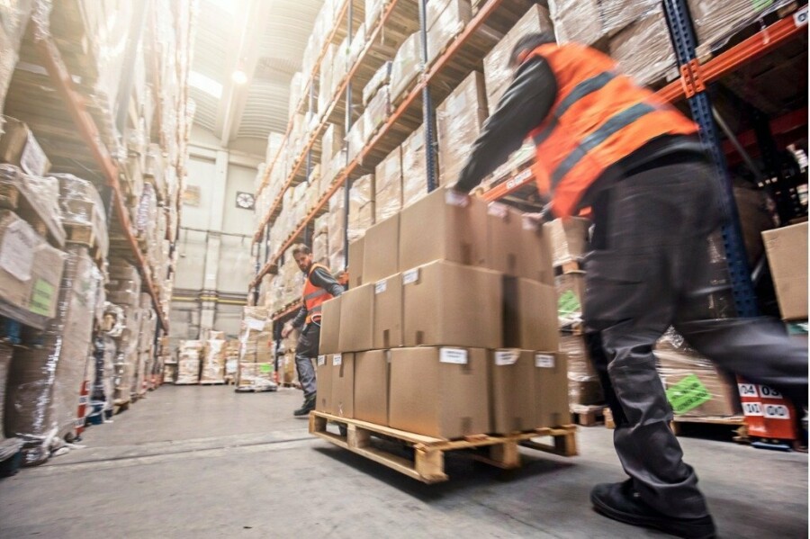 Motion blur of two men moving boxes in a warehouse picture id547406694
