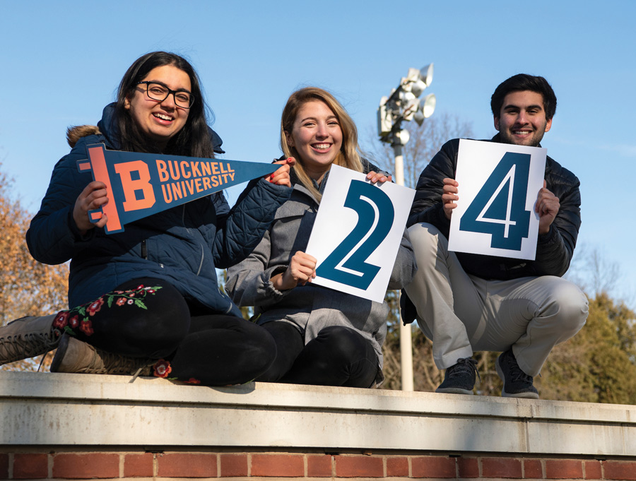 Students from Bucknell's Class of 2024 Bucknell students standing on a wall with spirit signs