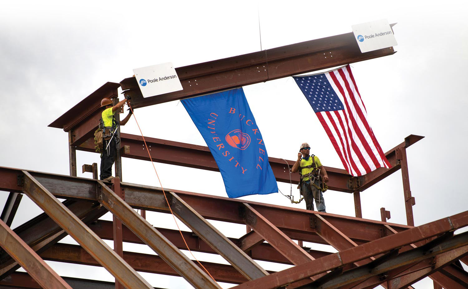 Construction workers install the final beam atop the new Freeman College of Management/Art & Art History Building Construction workers