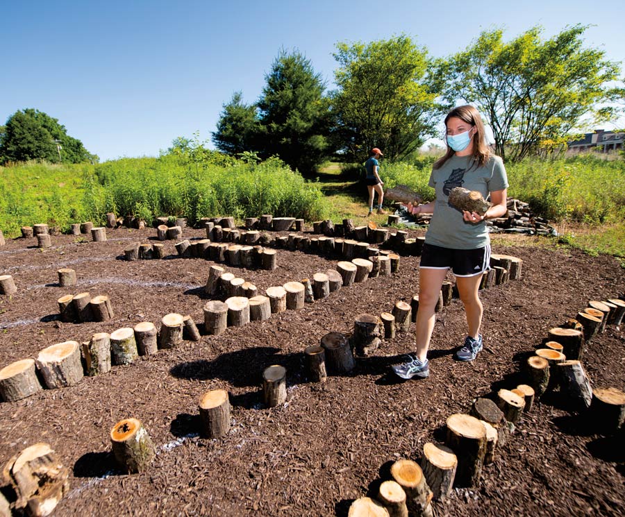 Kelsi Chuprinski helps build the labyrinth students working in the garden