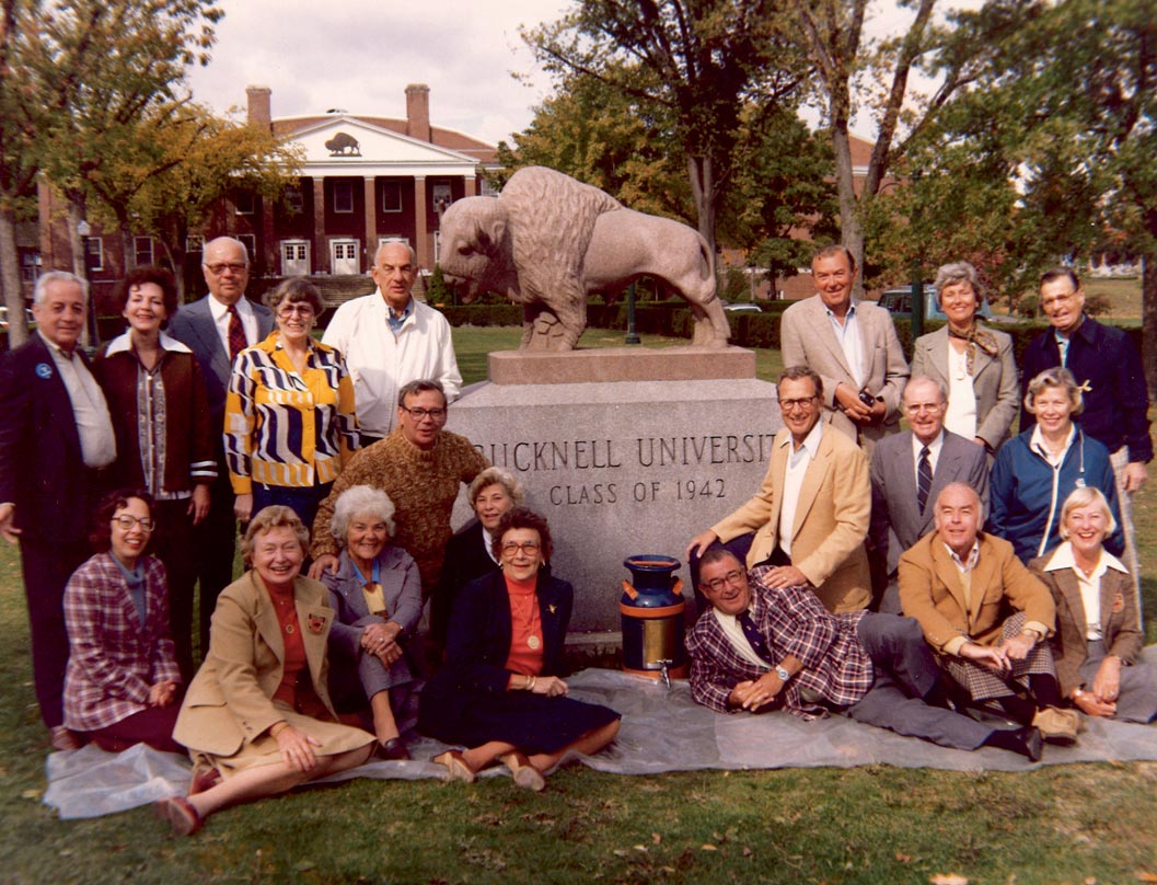A dedication from the class of 1942 A group picture with members from the class of 1942 in front of the stone class of '42 statue