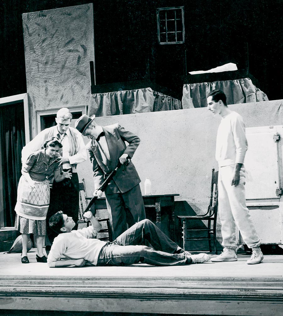 Vintage photograph of a play for Witty Winners Vintage photograph of a scene from a place where a man is holding an umbrella to another mans throat.