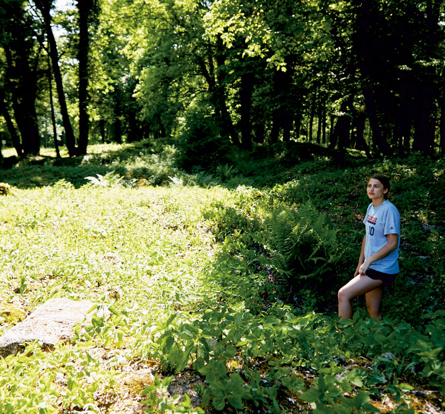 Someone standing under greenery Person standing under greenery