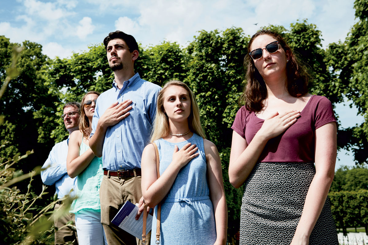 Students standing with hands over their hearts Students standing with their hands over their hearts
