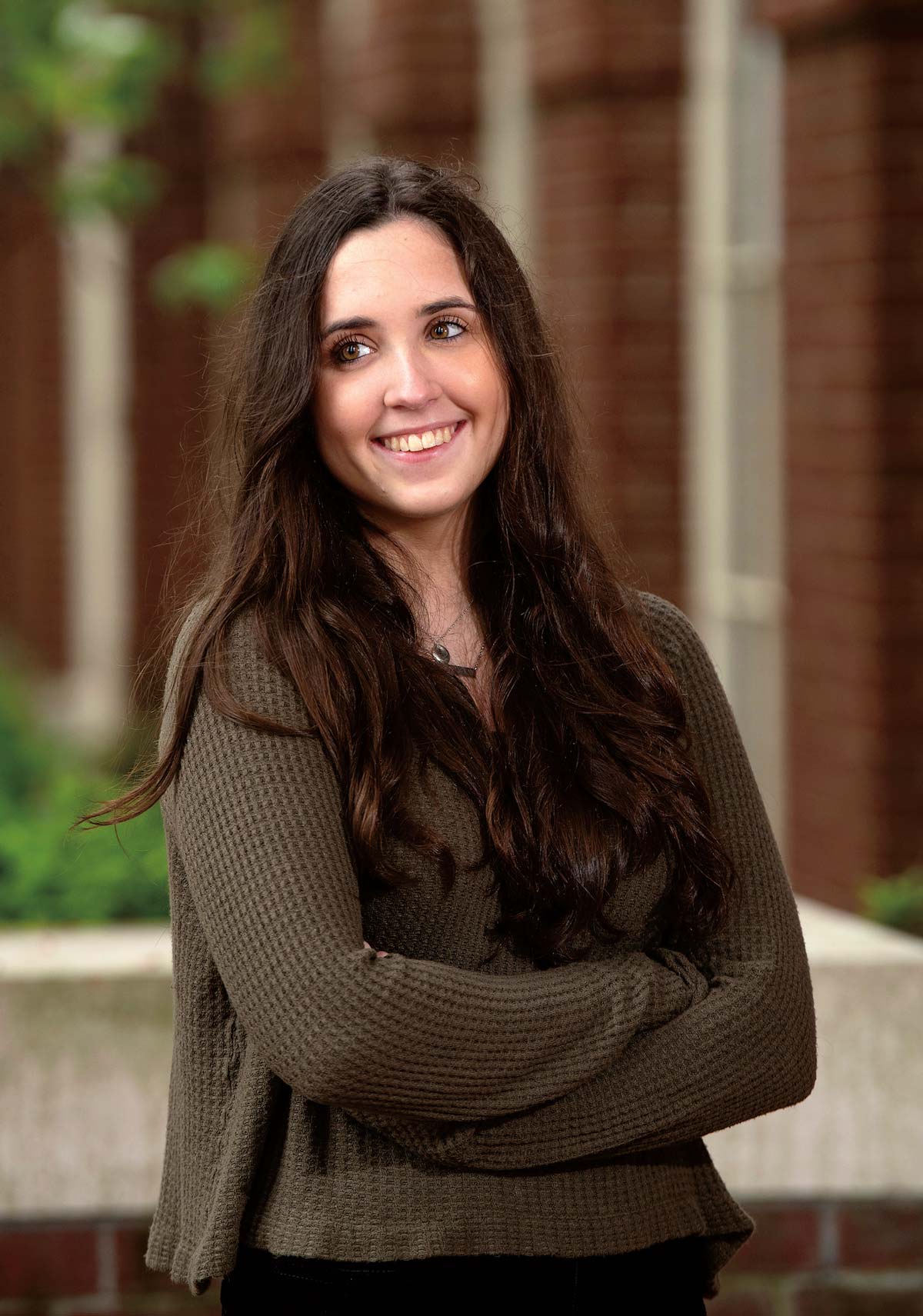 Sara Micciulli ’23 Portrait photo of Sara Micciulli ’23 smiling and looking away with crossed arms in a brown sweater