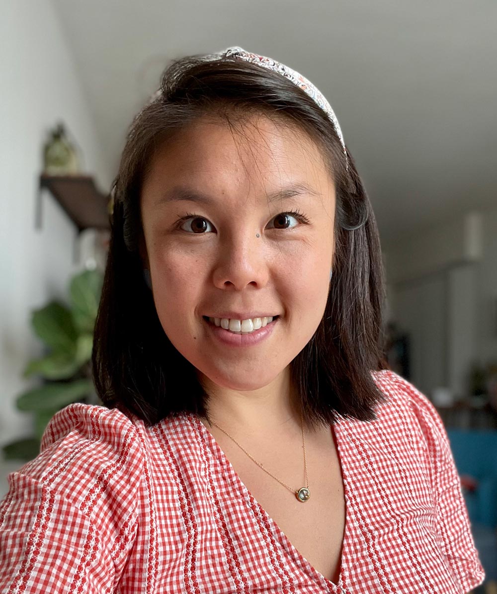 Chloe Chou Chloe Chou takes a selfie, smiling an wearing a red plaid blouse