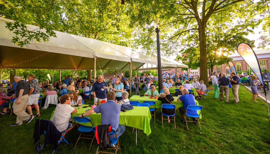 large group of people sitting at picnic tables at a Bucknell reunion