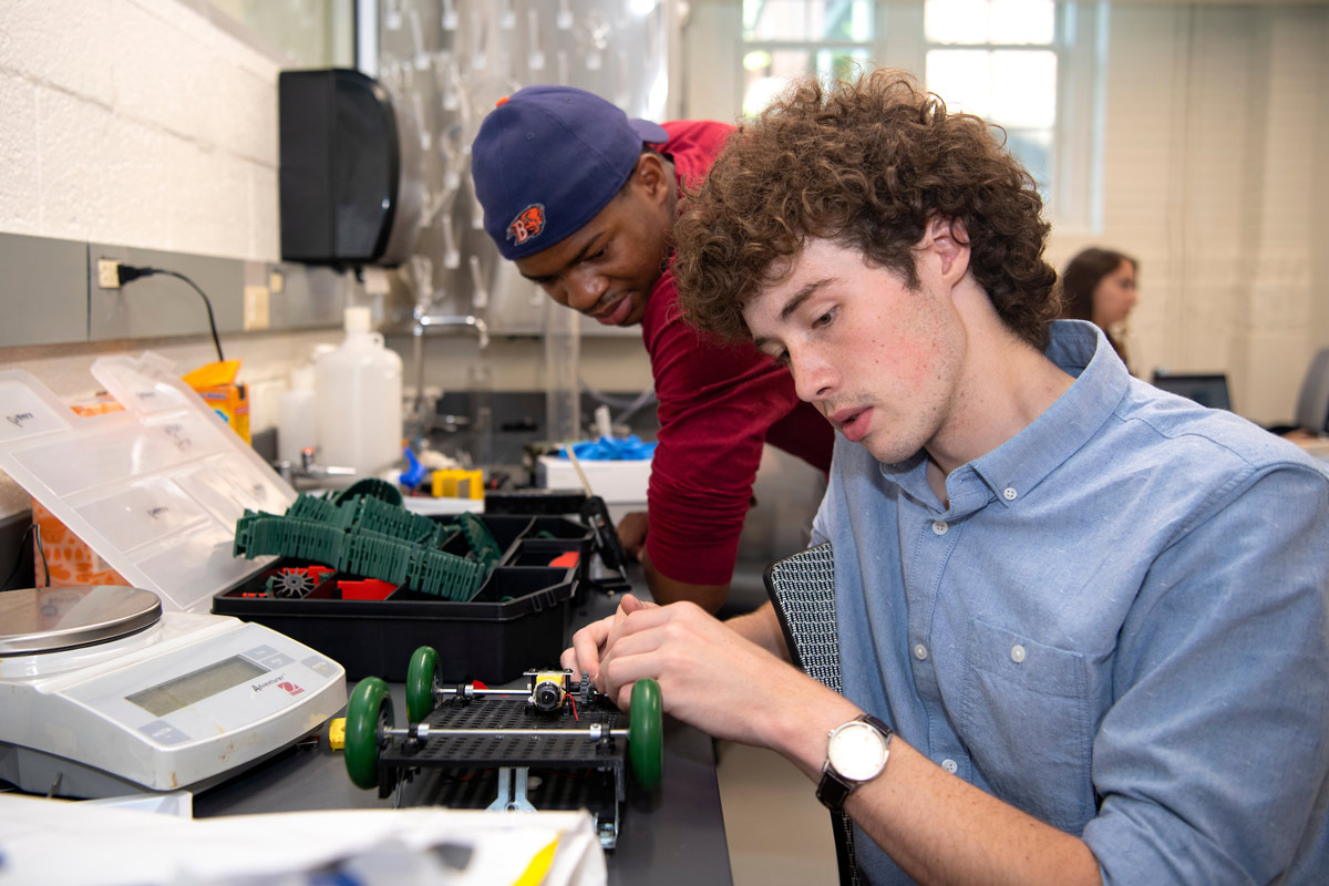 two men building a car powered by chemical reactions