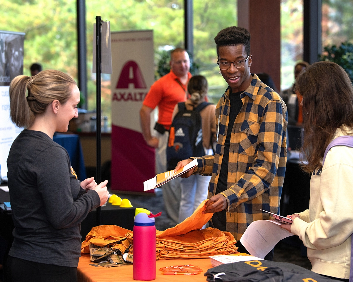students talk while being helped at a reception desk in the Center for Career Advancement