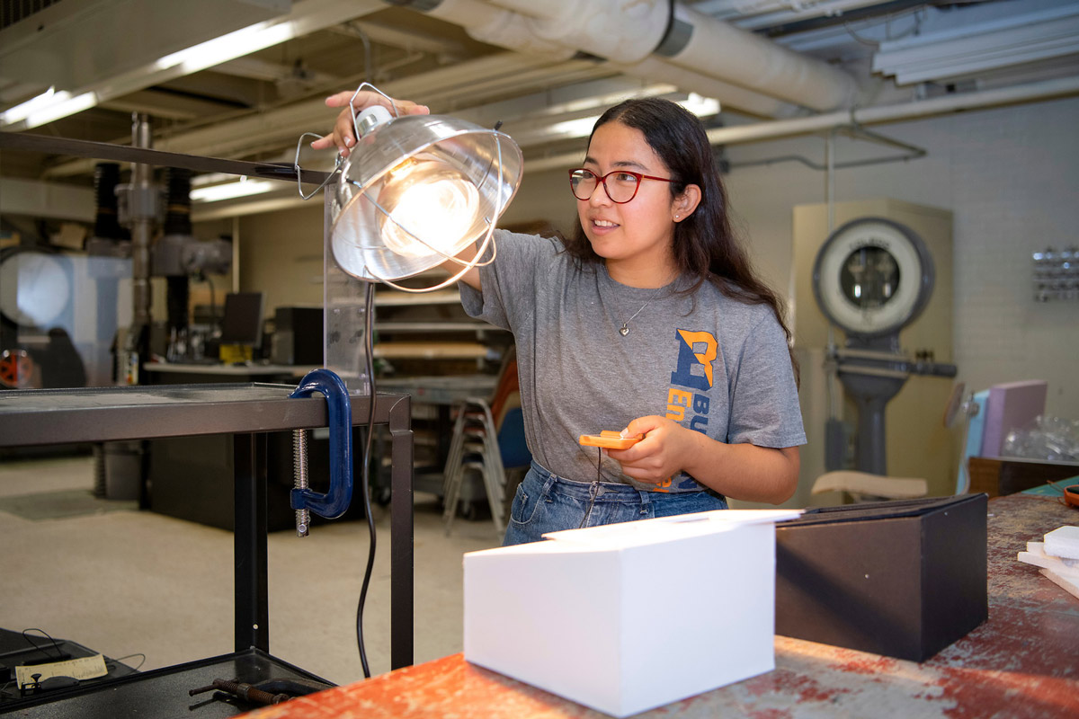 Cindy Cortz Cu working with a lamp in a lab
