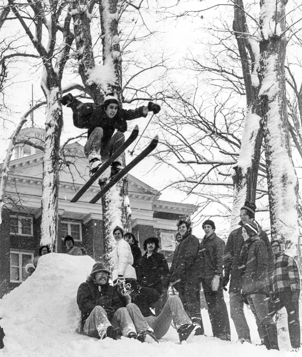 Witty Winners Peter Cree ’75 jumping off a snow ramp on skis