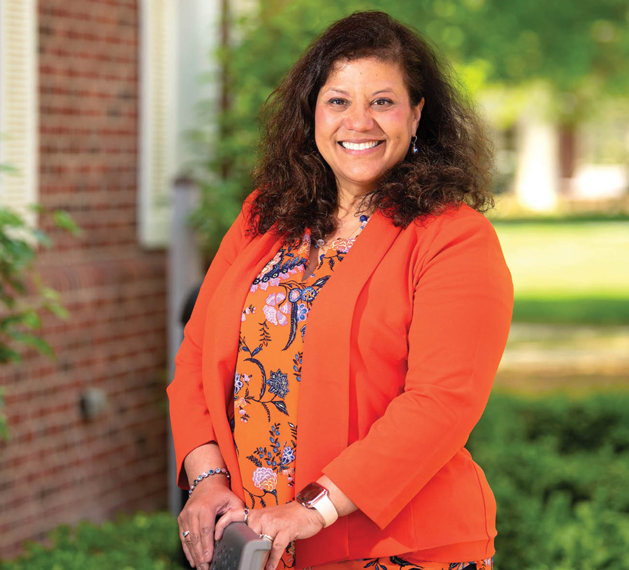 Caro Mercado smiling in an orange suit