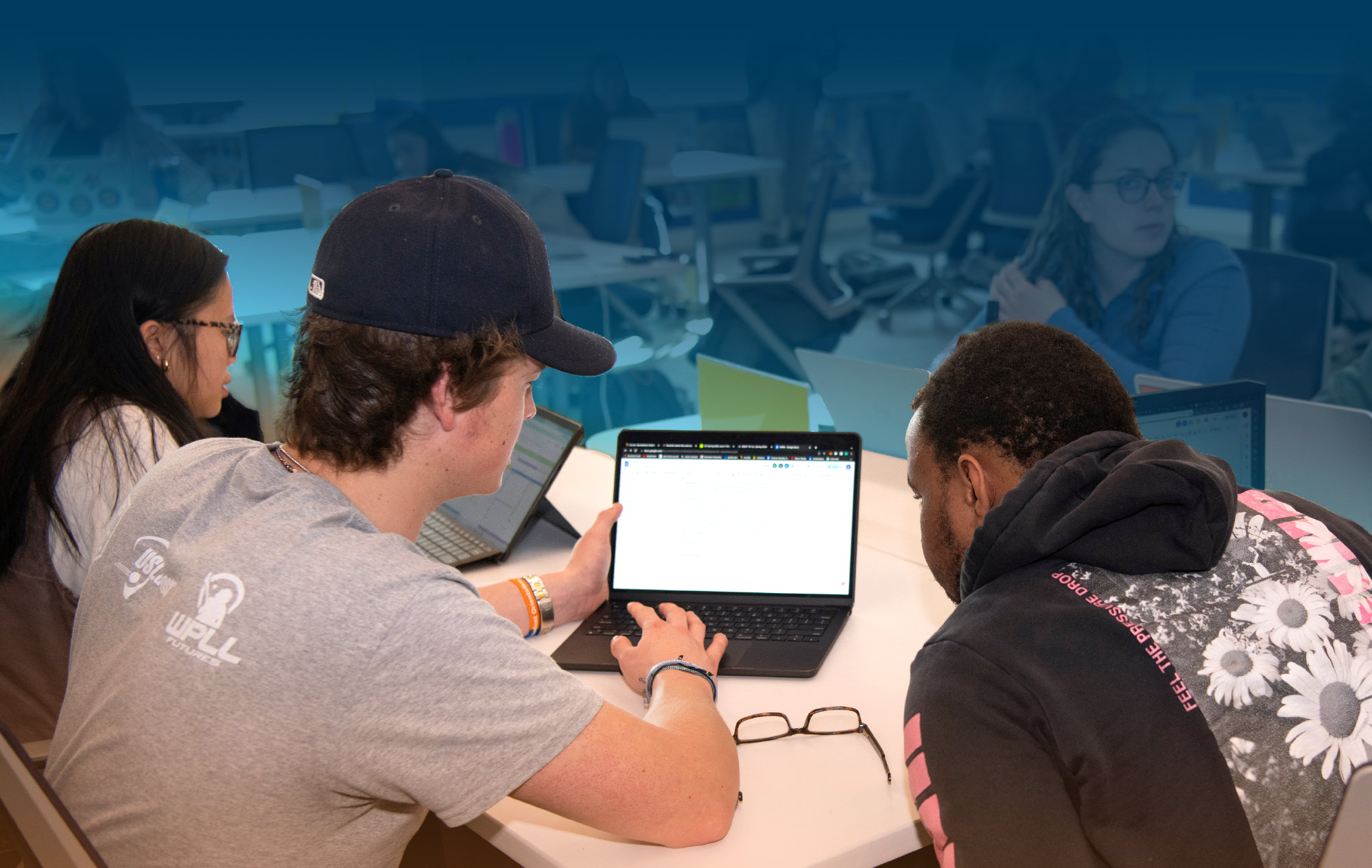 two students in computer lab looking at a laptop screen together