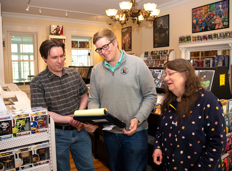 Jack Krasulak ’25 (center) provided guidance as a business analytics consultant to Albert and Laura Payne, owners of Comics Metropolis in Lewisburg.