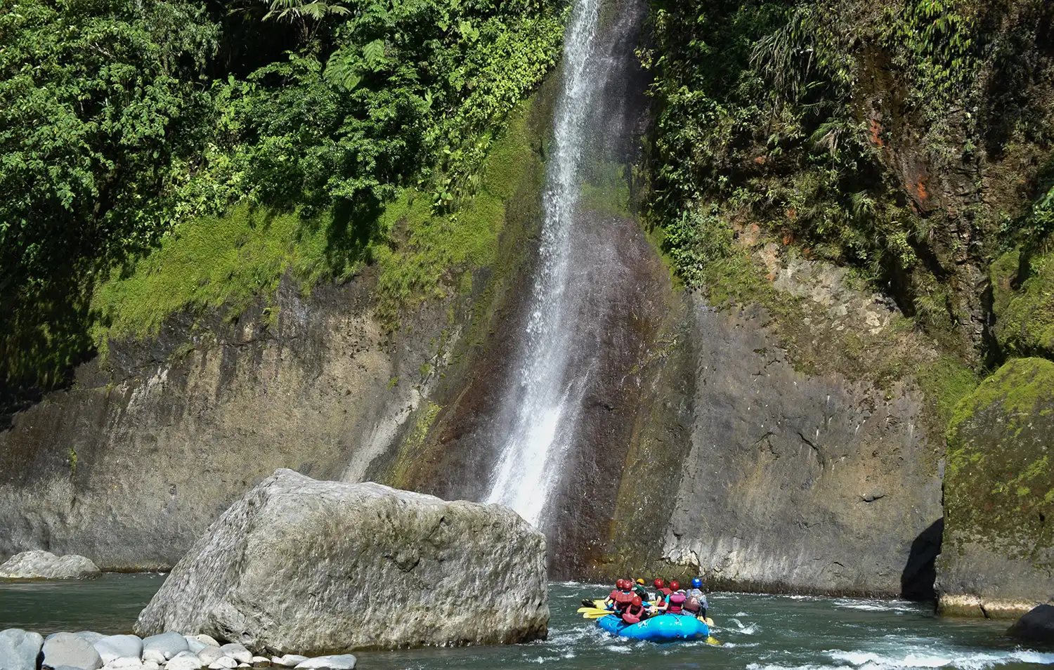 kayakers next to waterfall