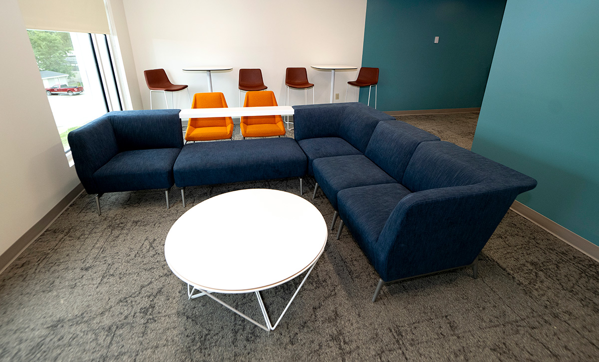 img-3 Blue sectional couch and a round white table in a campus housing facility