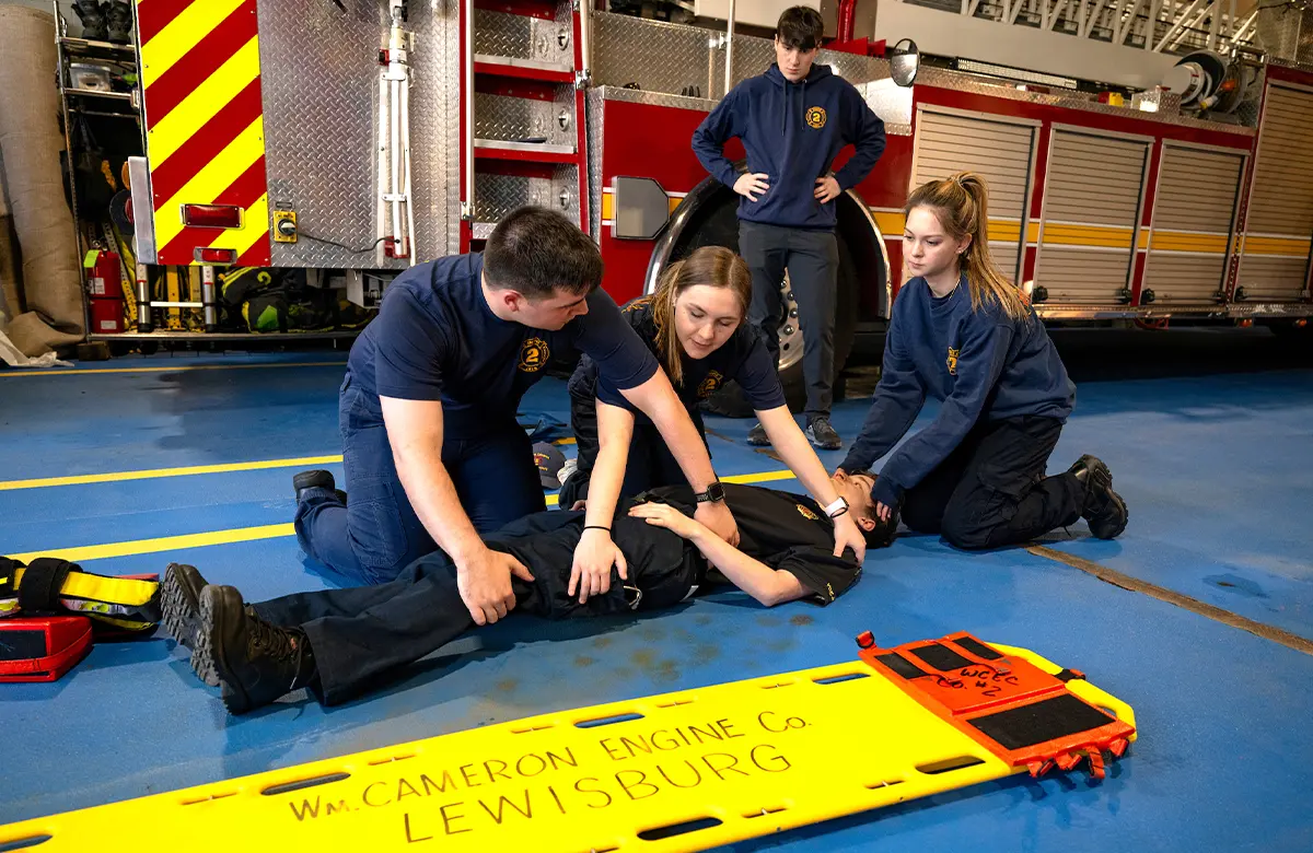 students perform a spinal immobilization exercise in a fire station