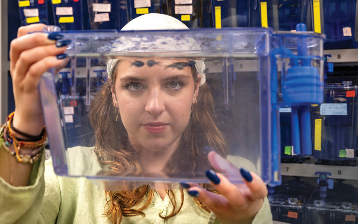 Capri Mills holding a tank of zebrafish