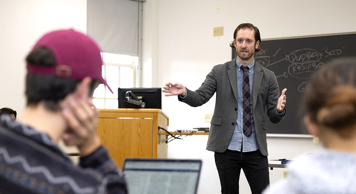 Professor John Penniman teaching at the front of a classroom