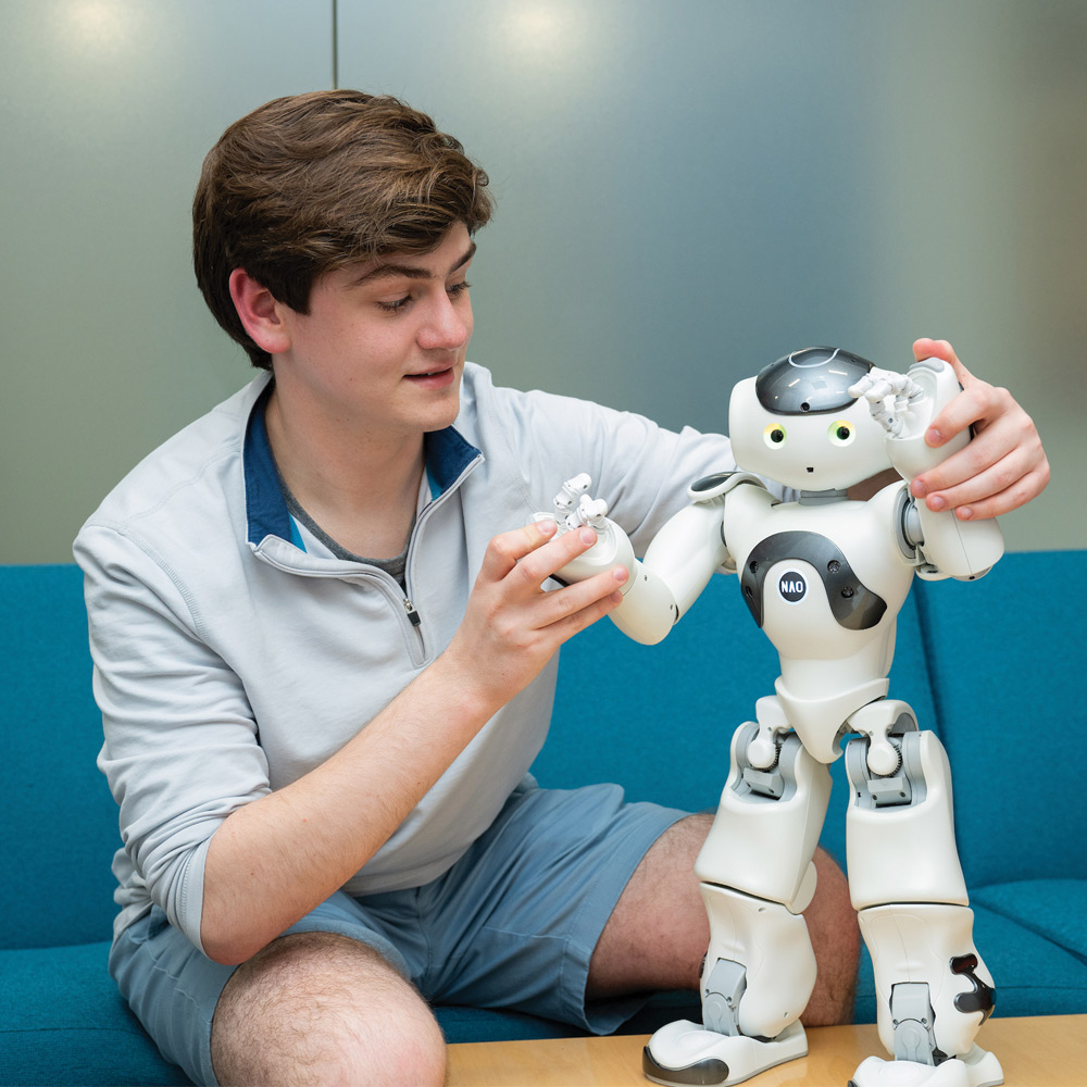 student holding robot by the arms