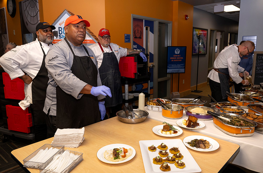 team of chefs preparing various dishes on a table