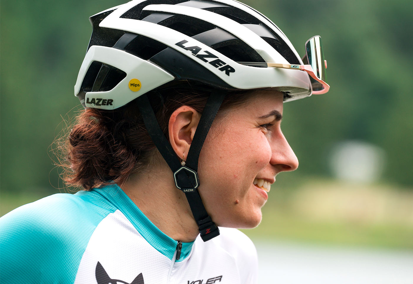 close candid shot of Kelly Desharnais Catale smiling while wearing her biking gear and a helmet