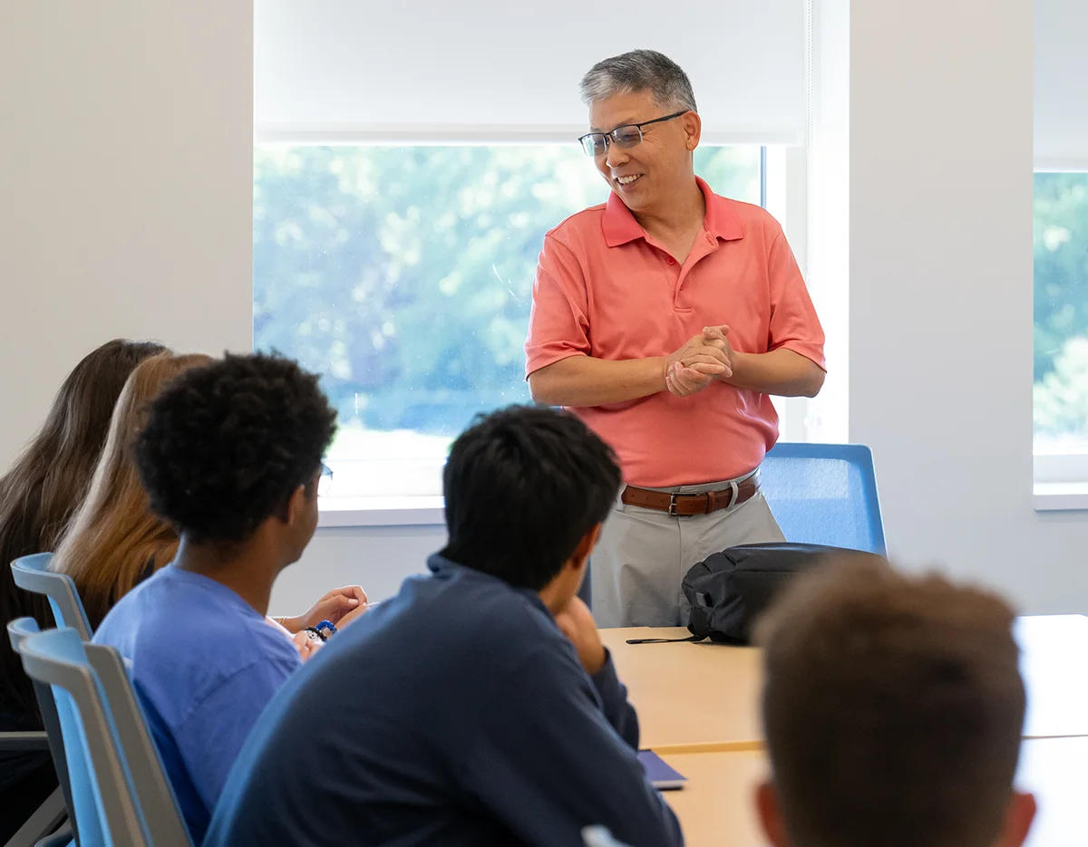 Professor Zhiqun Zhu giving a lecture to students seated at a table
