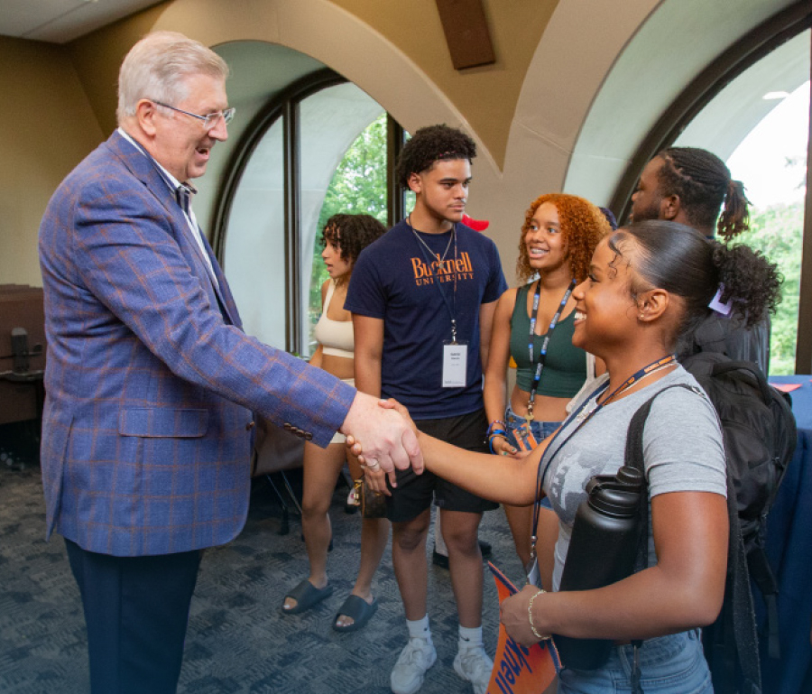 student shaking hands with John C. Bravman