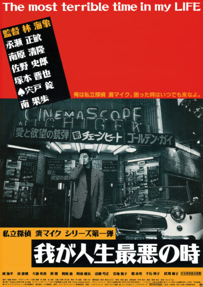 Theatrical poster for Kaizō Hayashi’s The Most Terrible Time in My Life. It features a black-and-white photograph of a man in a suit standing in front of a movie theater and an old car. He poses with his right hand over his right eye. It is designed with red and yellow backgrounds and Japanese text.