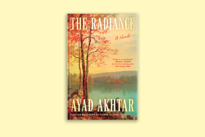 A book cover depicting a tree with orange leaves in the fall presiding over a lake. The title is “The Radiance” and the author is “Ayad Akhtar.”
