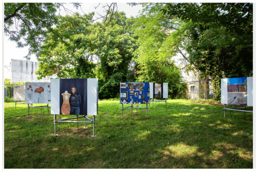 Color photograph of an installation of photographs, outside.
