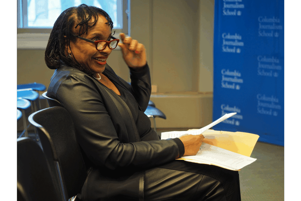 Color photograph of the artist seated with papers in her lap.