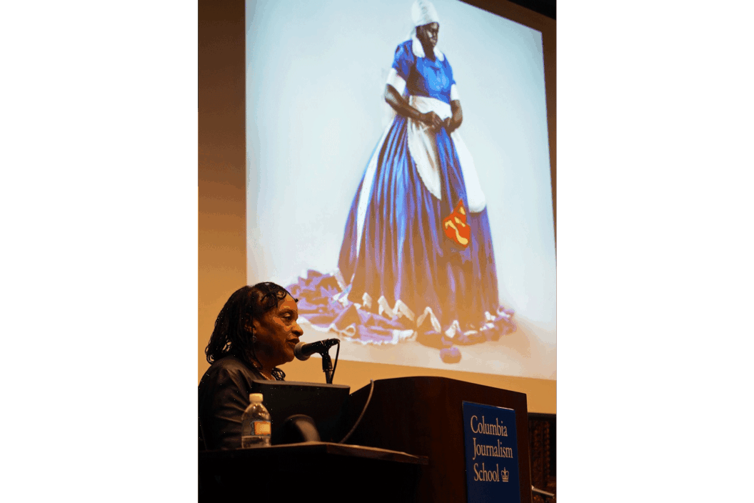 Color photograph of the artist at a lectern.