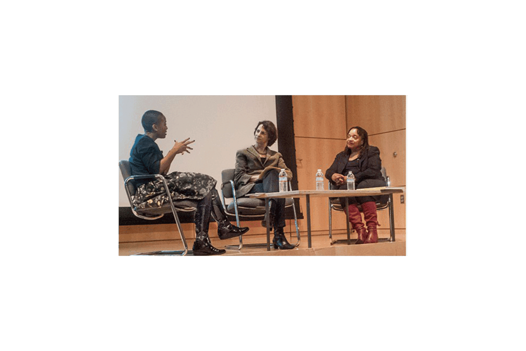 Color photograph of a panel discussion on a stage.