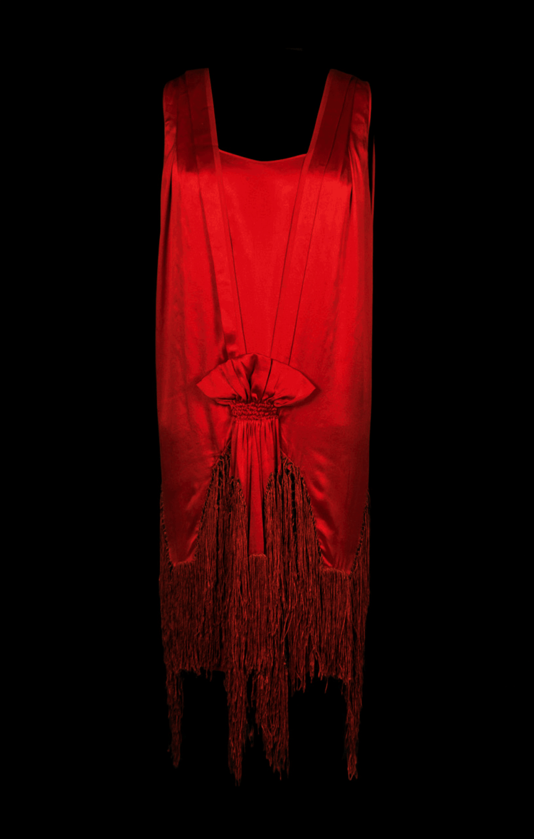 Color photograph of a red dress on a black background.