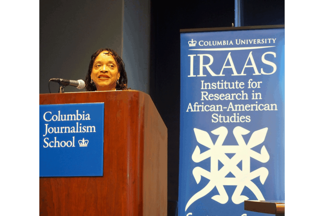 Color photograph of the artist at a lectern for IRAAS at Columbia.