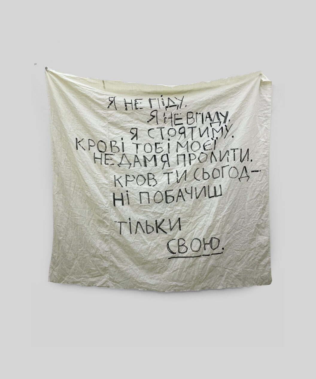 A photograph of a poem-prayer written in black ink on a white sheet.