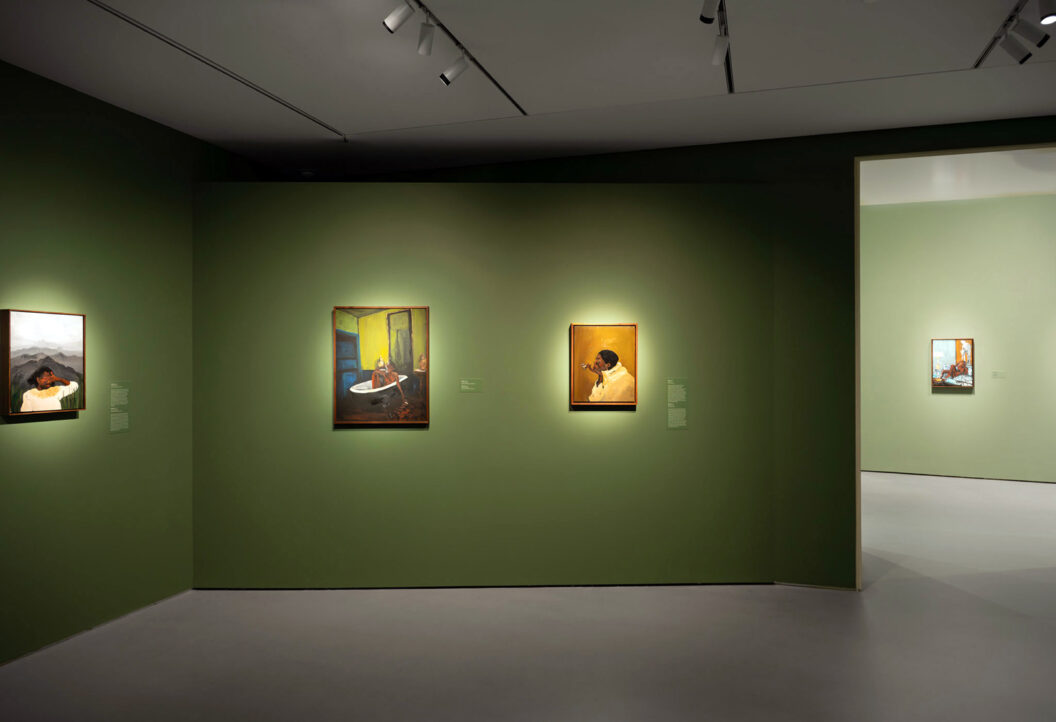 1600 An image of four paintings of Black women installed on three green walls.