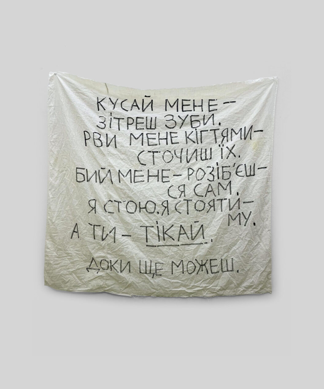 A photograph of a poem-prayer written in black ink on a plain white sheet.