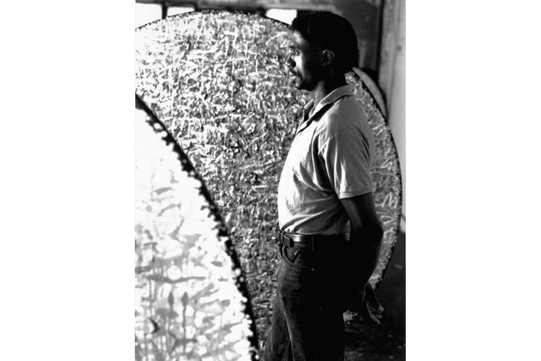 A profile photo of James Little in his Chelsea studio, while he looks out a window.