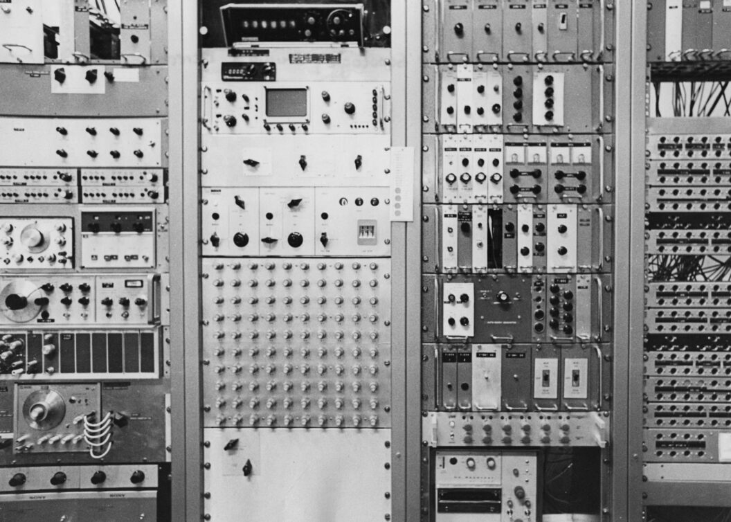 2824 A black-and-white photo of a computer with various knobs, screens, and buttons.