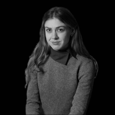 A black and white portrait of a young white woman in a gray sweater.