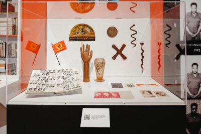 A display case with printed materials and small sculptural objects.