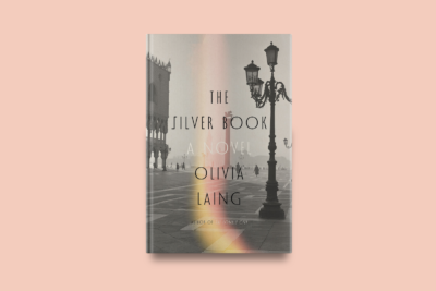 "Book cover for The Silver Book by Olivia Laing showing a misty Venice plaza with ornate streetlamps, the Doge's Palace tower, and silhouetted figures in atmospheric fog with rainbow light flare"