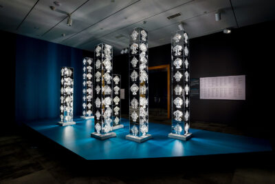 A set of vertical sculptures illuminated from within.