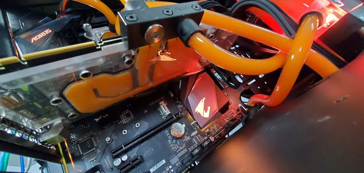 Close up of orange coolant lines inside a water cooled PC