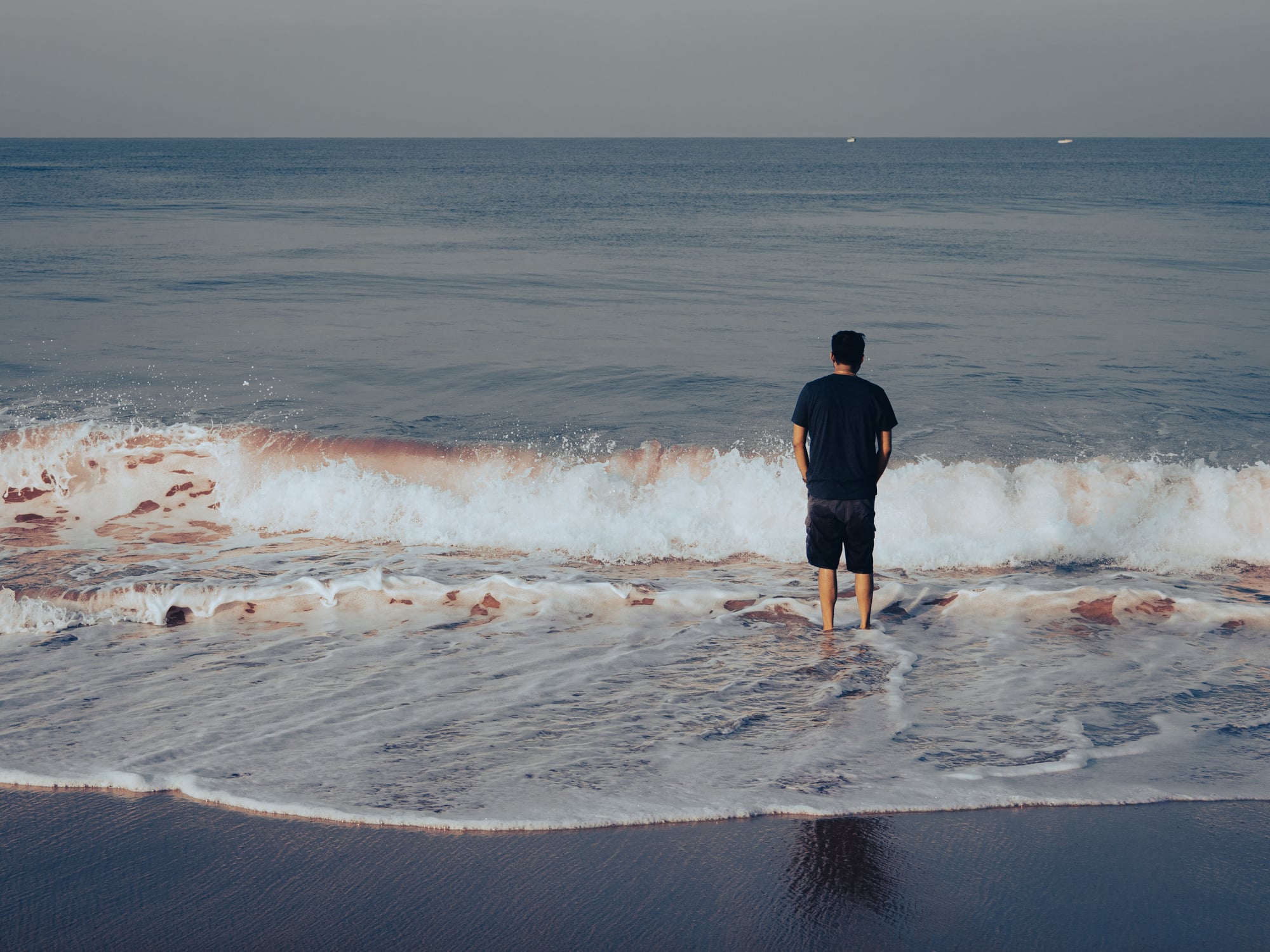 Person standing at ocean's edge