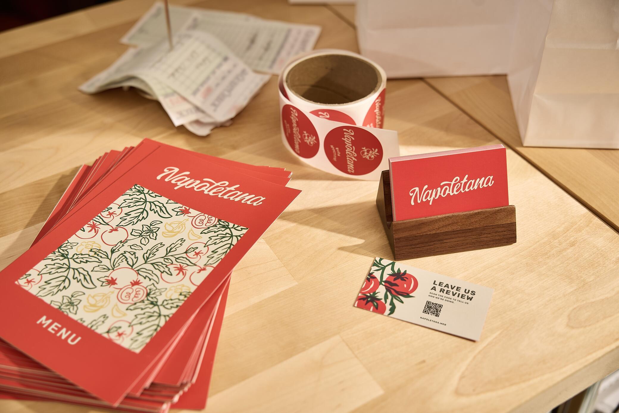 A table with red cards and a roll of paper showing Vistaprint's print marketing options.